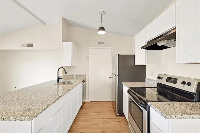 a kitchen with stainless steel appliances granite countertop a sink stove and refrigerator