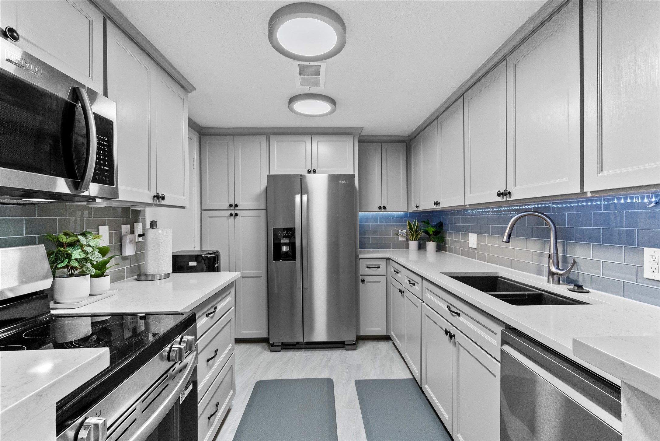 604 South Ripple Creek Drive, Unit 604 Houston, TX 77057 - Photo 3 of 31 a kitchen with stainless steel appliances a sink a stove a microwave a refrigerator a stove and cabinets