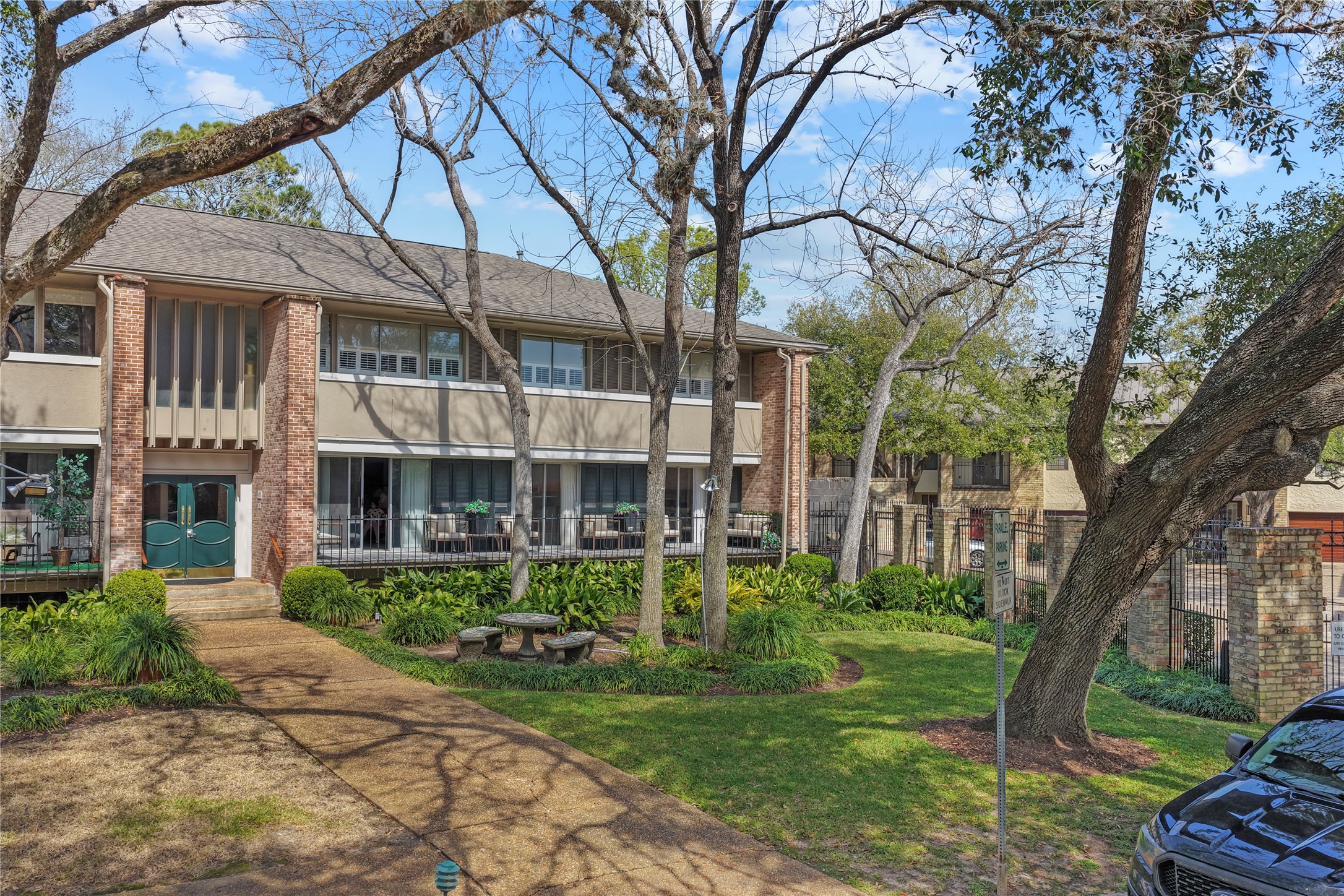 604 South Ripple Creek Drive, Unit 604 Houston, TX 77057 - Photo 6 of 31 a view of a brick building next to a large tree
