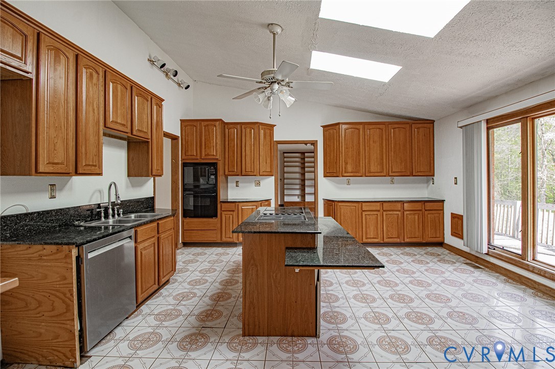 10720 Kimages Road Charles City, VA 23030 - Photo 16 of 55 a kitchen with stainless steel appliances granite countertop a stove top oven a sink dishwasher a dining table and chairs with wooden floor