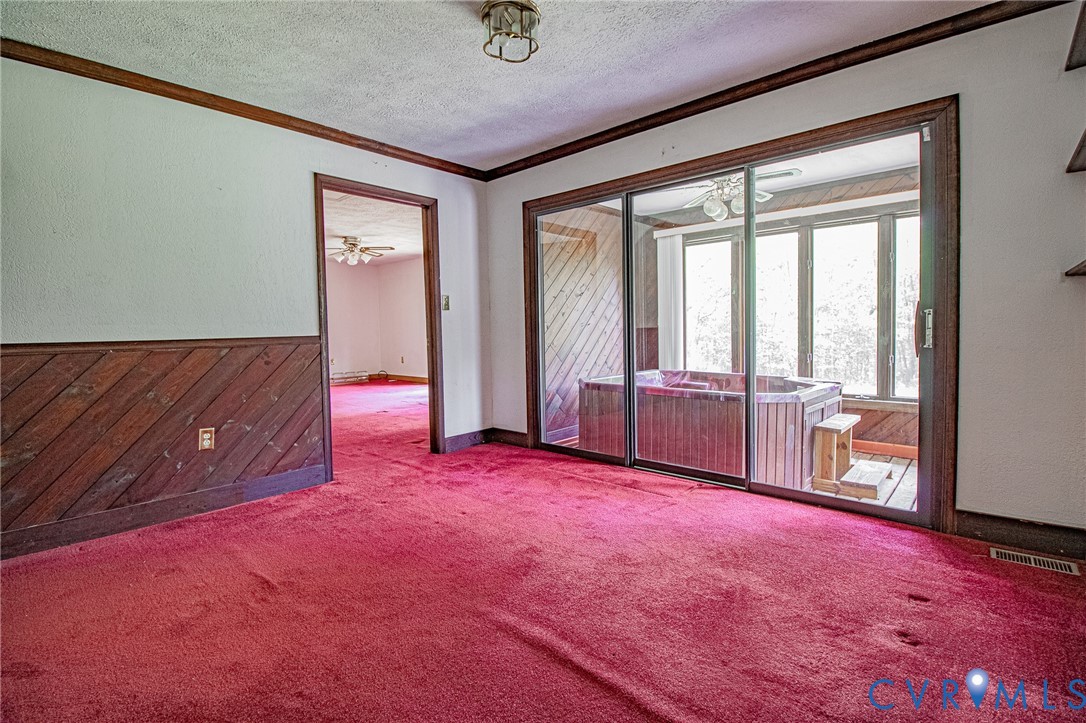 10720 Kimages Road Charles City, VA 23030 - Photo 25 of 55 an empty room with chandelier fan and windows