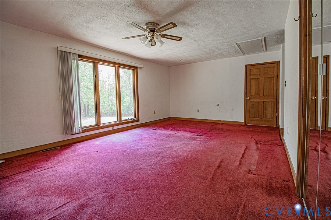 10720 Kimages Road Charles City, VA 23030 - Photo 26 of 55 an empty room with chandelier fan and windows