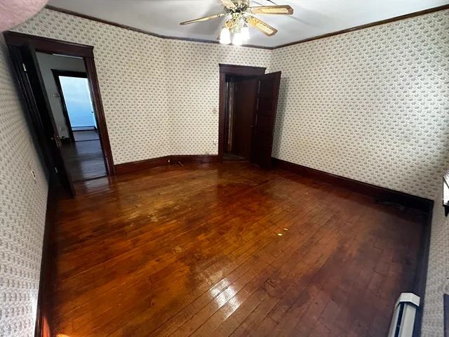 a view of an empty room with wooden floor
