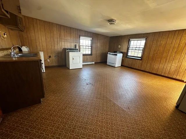 a kitchen with stainless steel appliances kitchen island granite countertop a refrigerator stove and sink