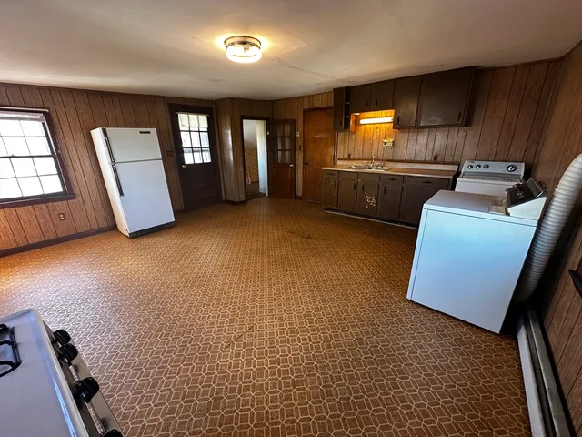 a view of an empty room with windows & cabinet