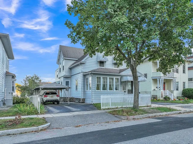 a front view of a house with a garden and trees