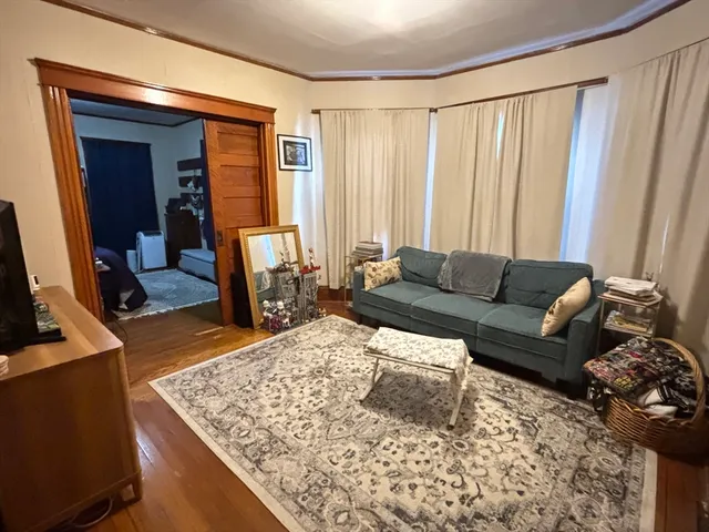 a living room with a couch and a dresser next to a window