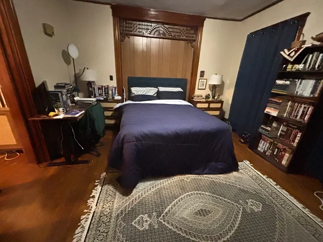 a bedroom with a bed and dresser with shower