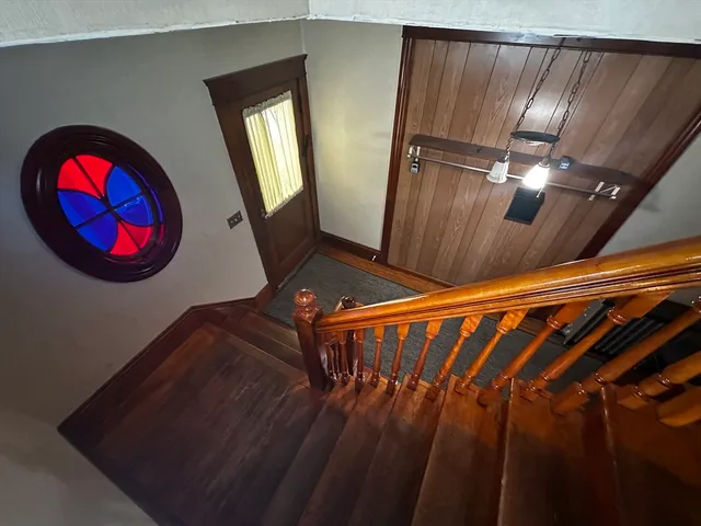 a view of staircase with railing and a chandelier