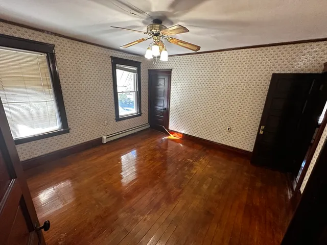 en empty room with windows and ceiling fan
