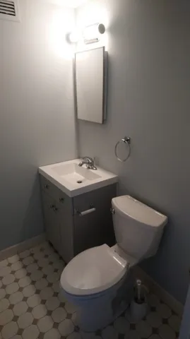 a bathroom with a toilet a sink and mirror