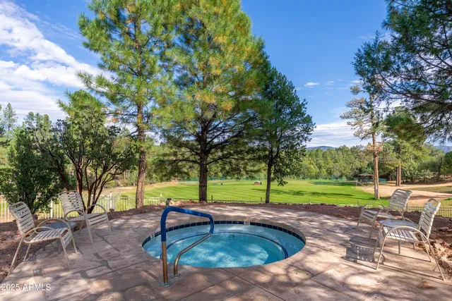 a view of a swimming pool with lawn chairs under an umbrella