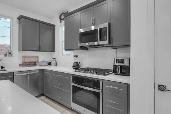 a kitchen with stainless steel appliances a stove microwave and sink