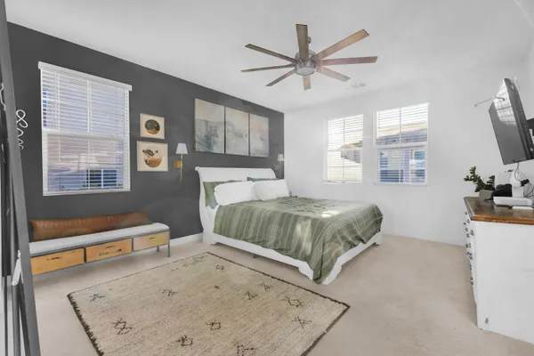 a bedroom with a bed a dresser next to a window