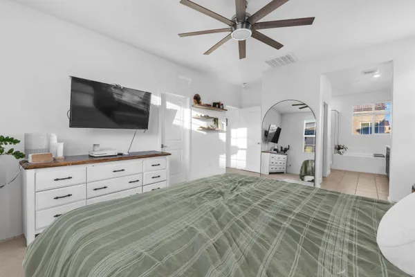 a bedroom with a large bed and a flat screen tv