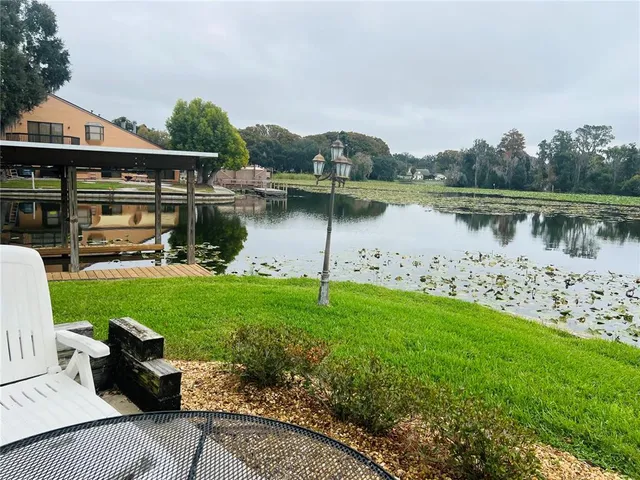 a view of a lake with a yard and a fountain