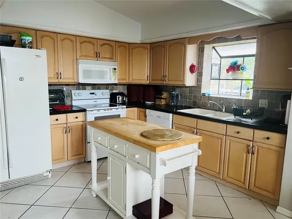 a kitchen with a sink a stove a refrigerator and cabinets