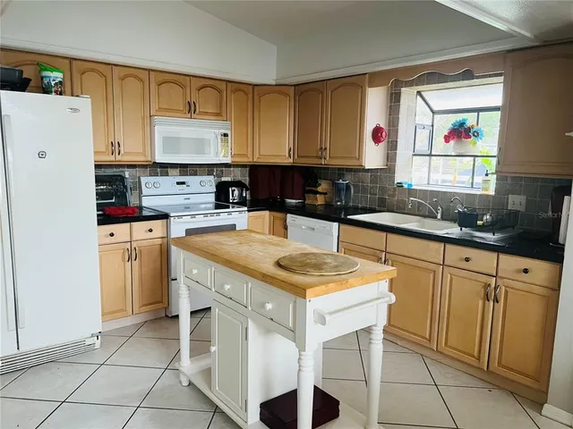 a kitchen with a sink a stove a refrigerator and cabinets