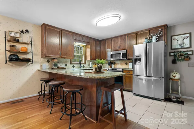 a kitchen with stainless steel appliances granite countertop a refrigerator and a stove top oven