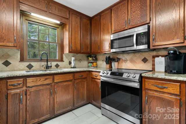 a kitchen with stainless steel appliances granite countertop a stove microwave and sink