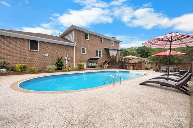 a view of a backyard with a patio and swimming pool