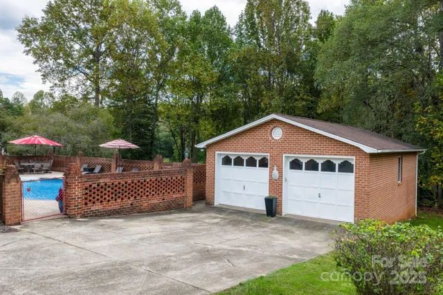 a view of a house with a yard and large trees