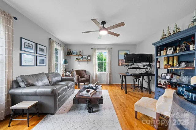 a living room with furniture a bookshelf and a window