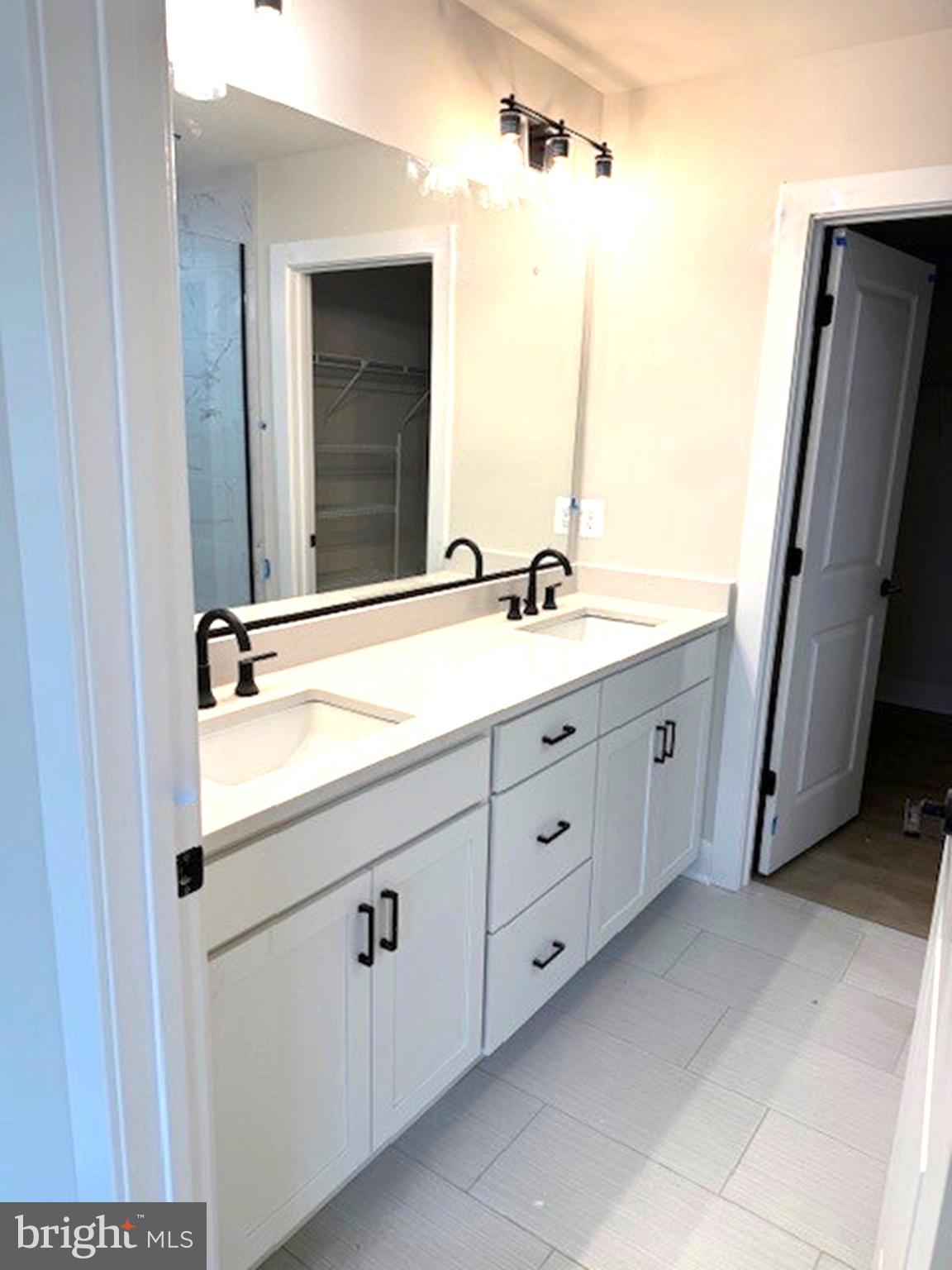 163 Merrick Way Ocean View, DE 19970 - Photo 6 of 10 a spacious bathroom with a double vanity sink a large mirror and a shower