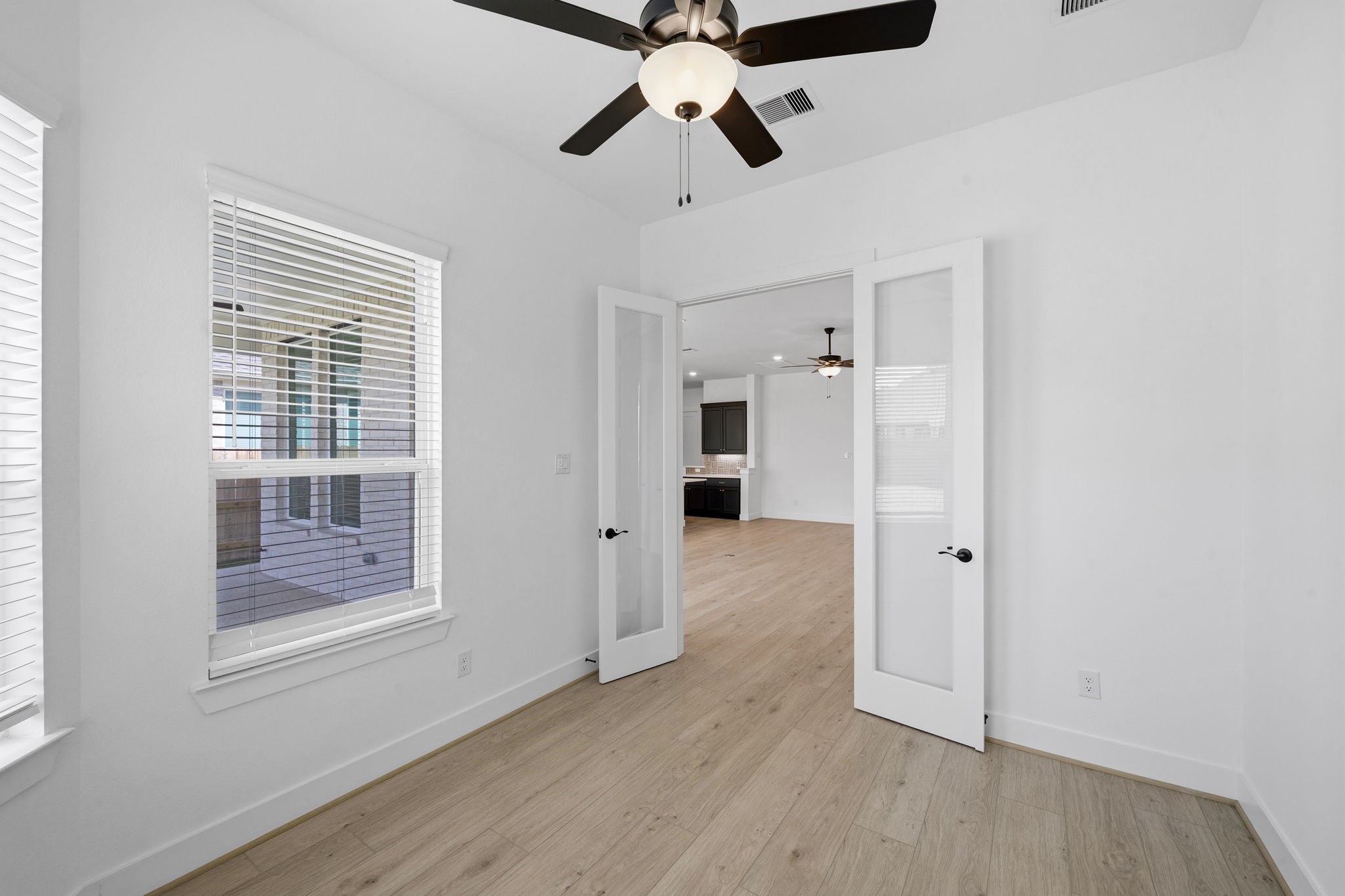18103 Scarlett Hummingbird Court Conroe, TX 77302 - Photo 13 of 43 a view of an empty room with a window and wooden floor