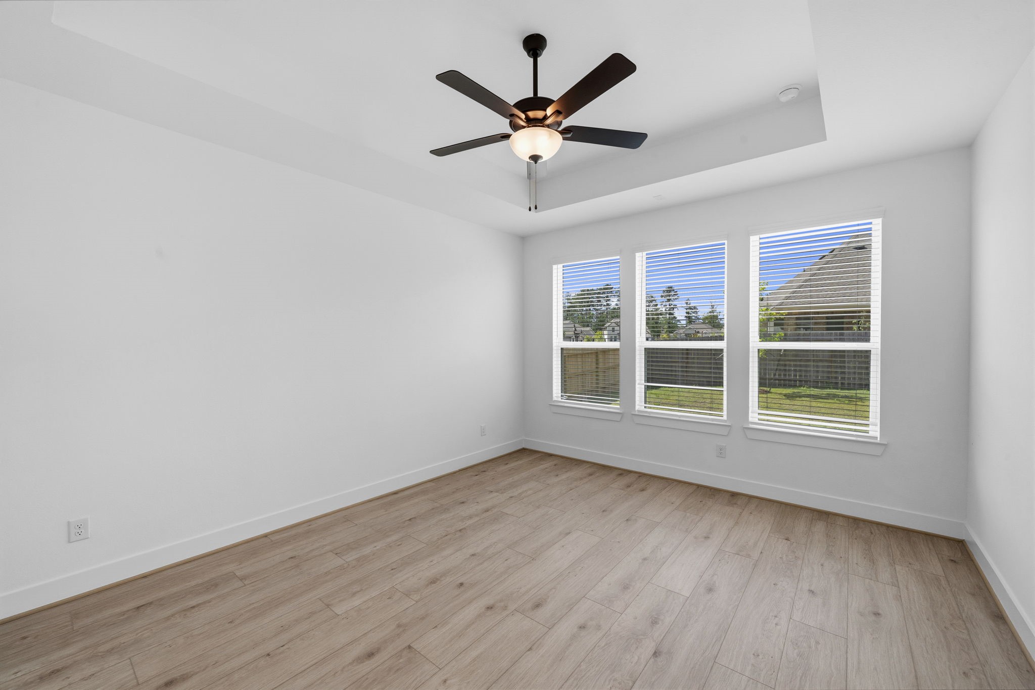 18103 Scarlett Hummingbird Court Conroe, TX 77302 - Photo 14 of 43 an empty room with wooden floor fan and windows