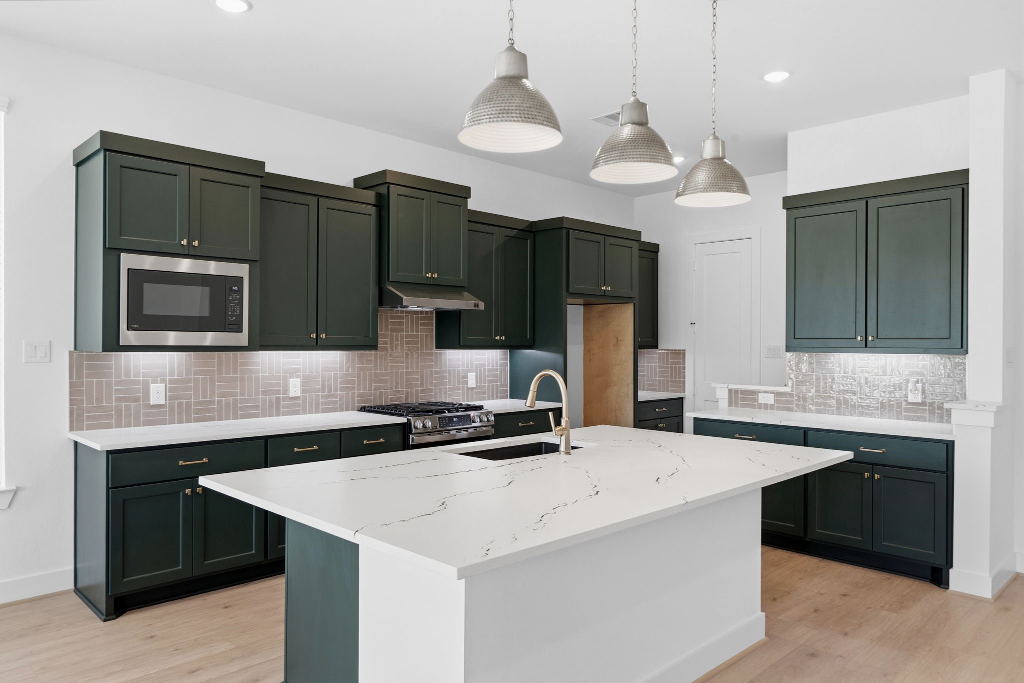18103 Scarlett Hummingbird Court Conroe, TX 77302 - Photo 2 of 43 a kitchen with a sink a microwave a stove and refrigerator