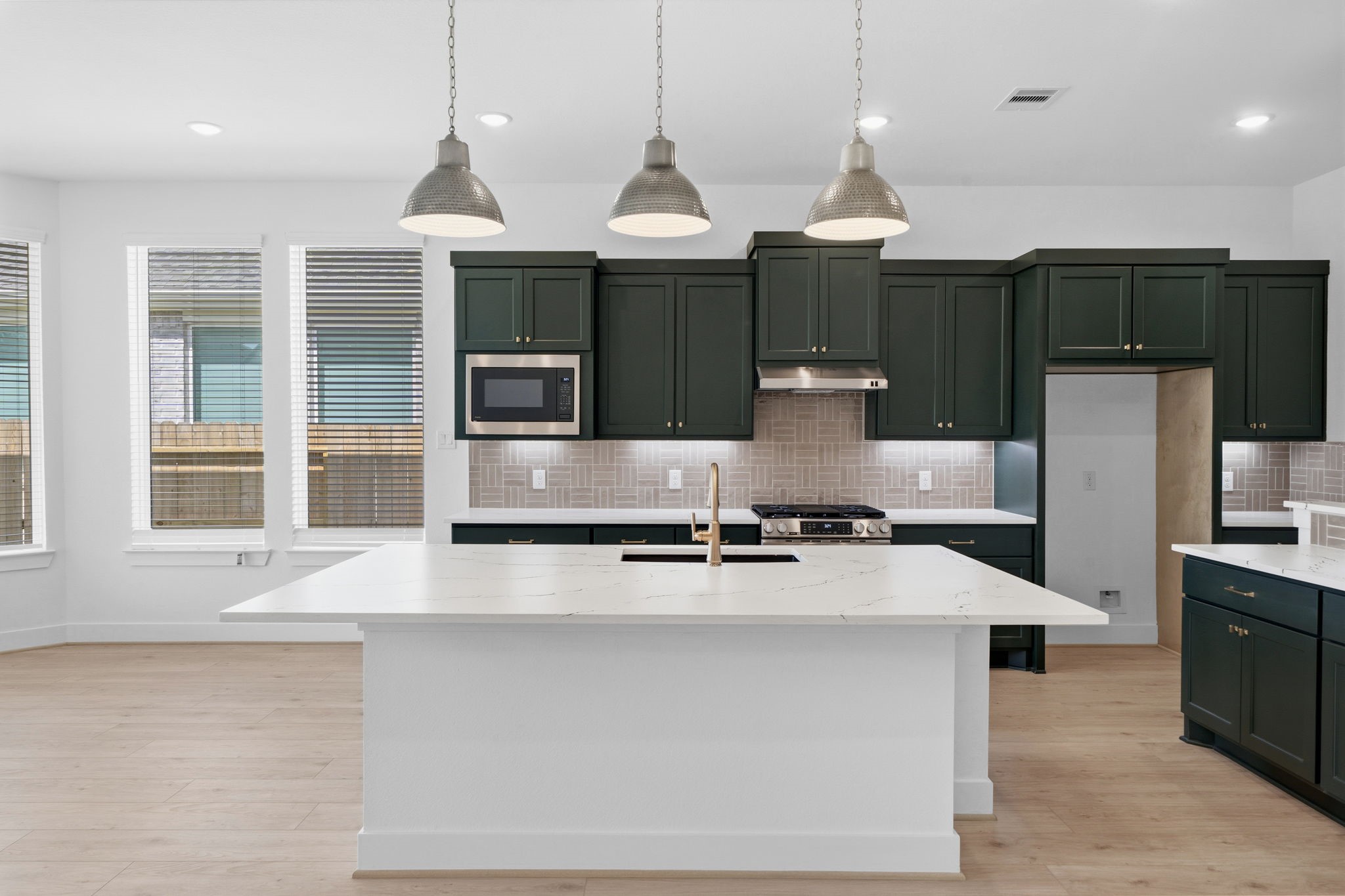 18103 Scarlett Hummingbird Court Conroe, TX 77302 - Photo 6 of 43 a large kitchen with kitchen island a large counter top stainless steel appliances and cabinets