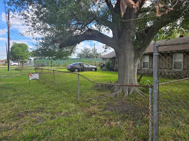 a view of a house with a backyard and a tree