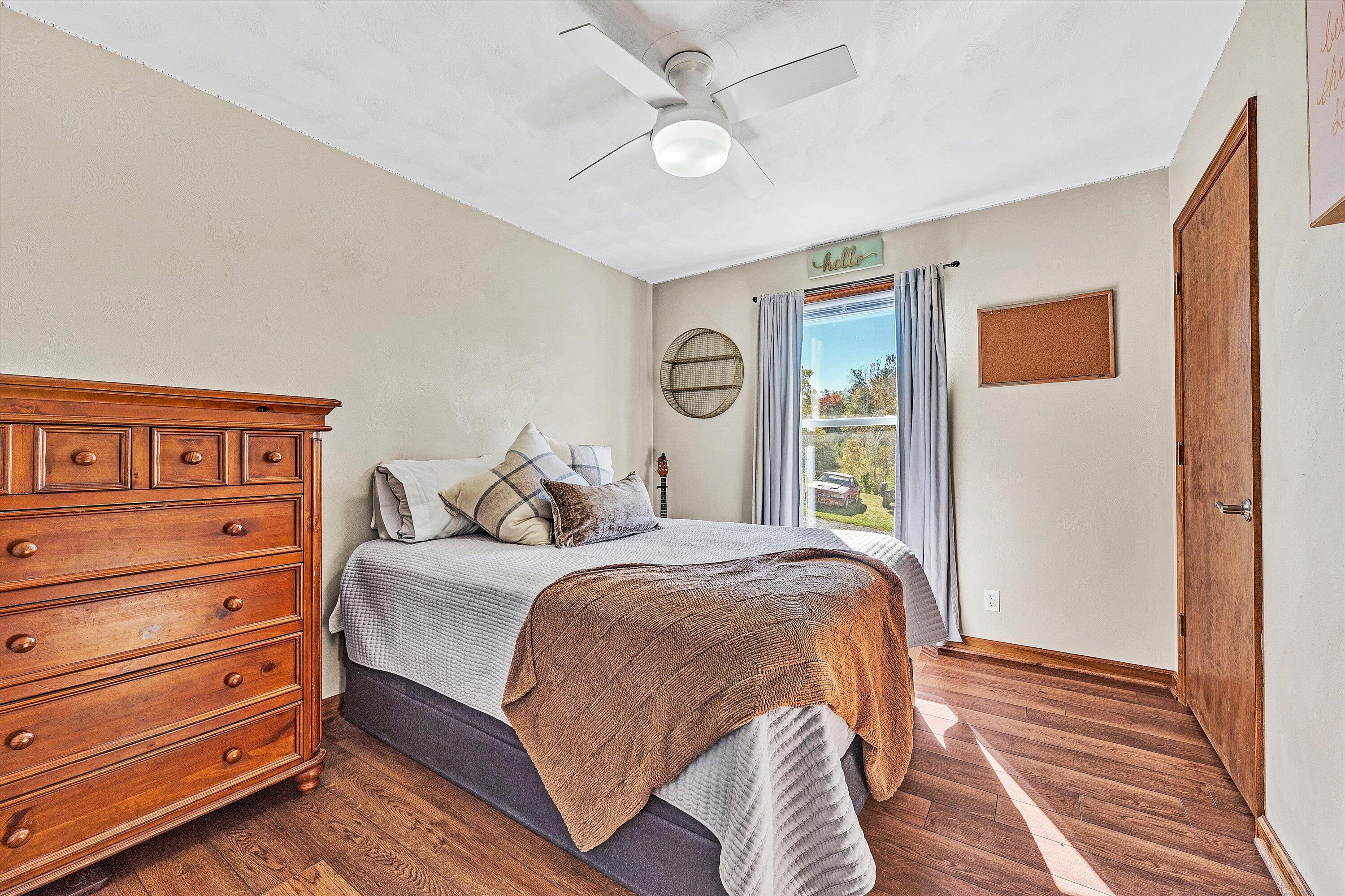 99 Spruce Lane Callaway, VA 24067 - Photo 12 of 19 a bedroom with a large bed and a chandelier