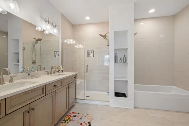 a bathroom with a tub sink shower and two mirror