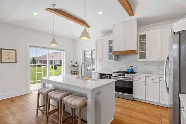 a kitchen with stainless steel appliances granite countertop a stove refrigerator sink and cabinets
