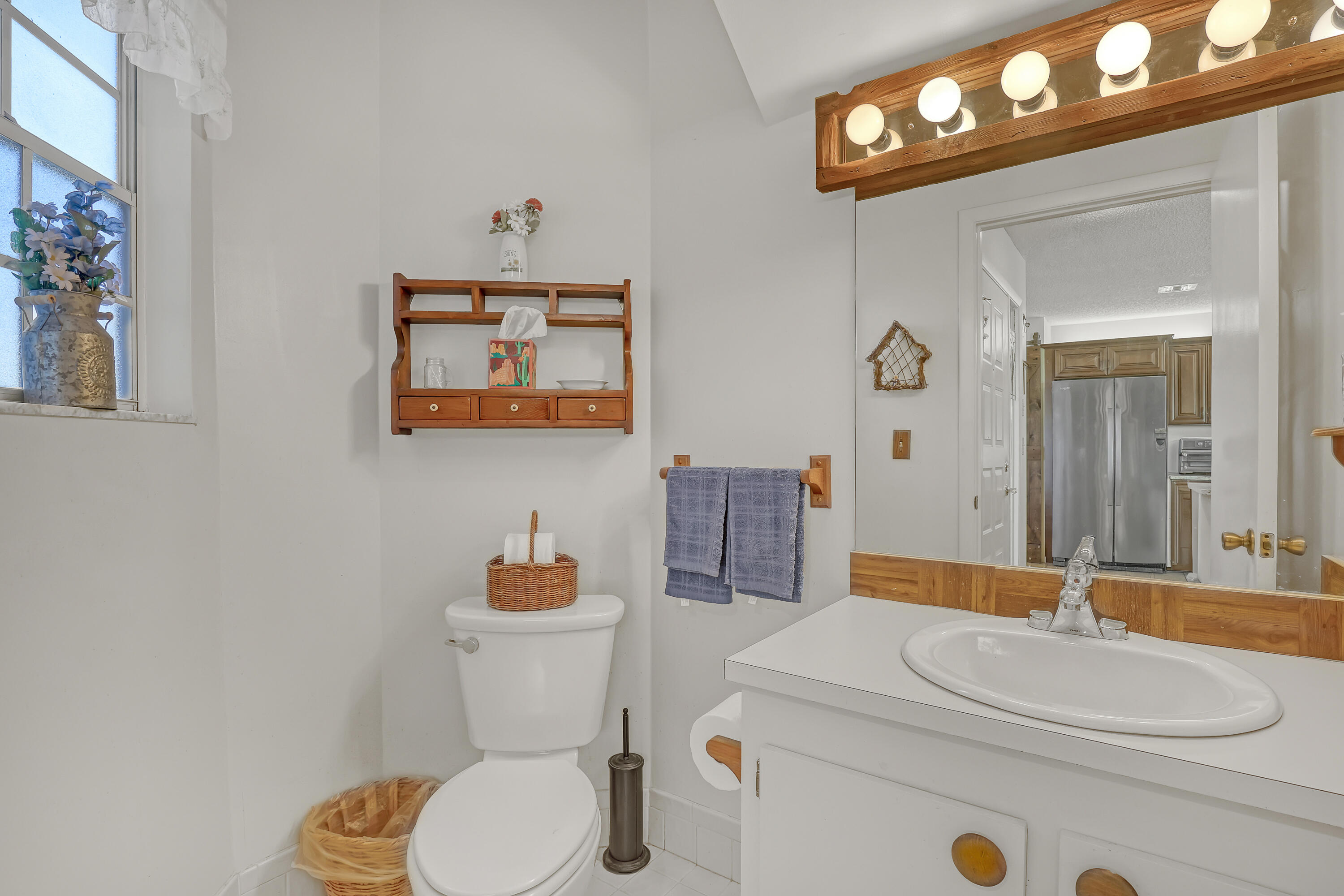 13116 Quiet Woods Road, Unit A Wellington, FL 33414 - Photo 15 of 31 a bathroom with a sink a toilet and a mirror