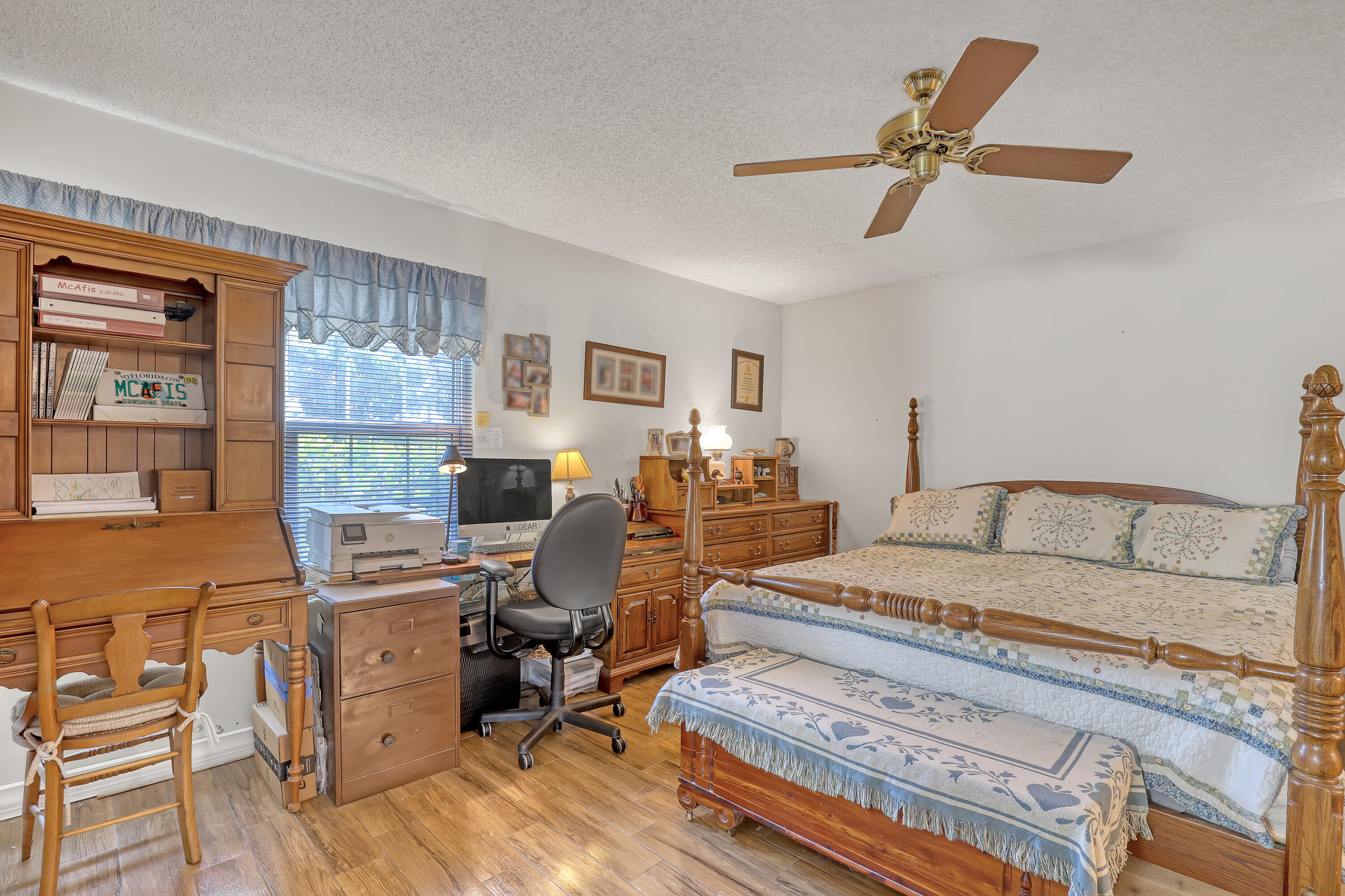 13116 Quiet Woods Road, Unit A Wellington, FL 33414 - Photo 16 of 31 a bedroom with a bed a computer on the desk and a dresser