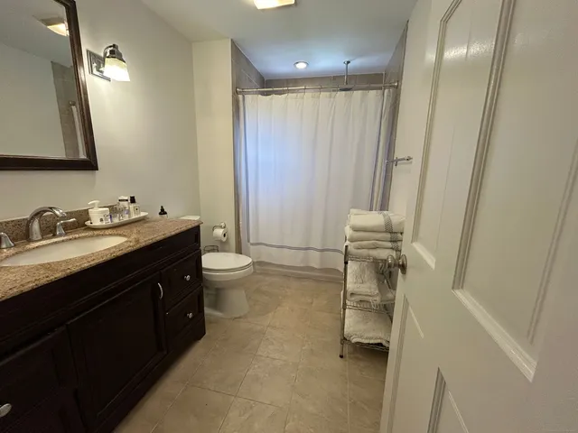 a bathroom with a double vanity sink toilet and a mirror