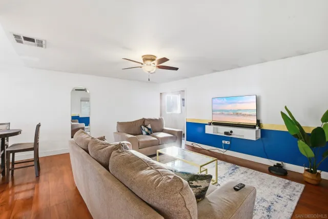 a living room with furniture and wooden floor