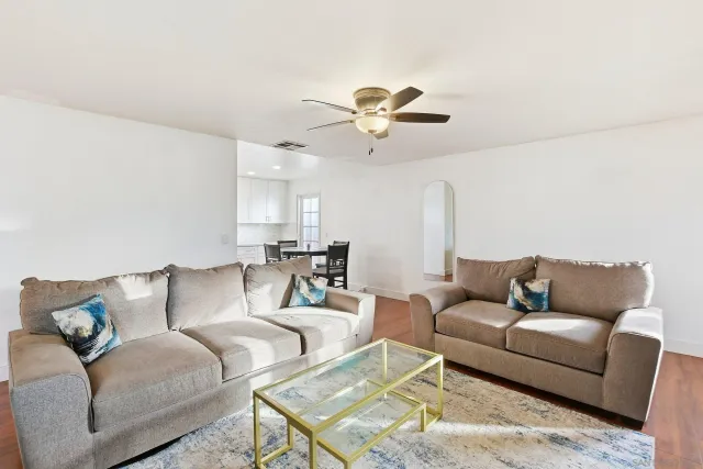 a living room with furniture ceiling fan and a rug