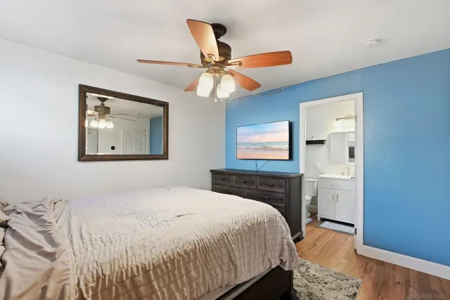 a bedroom with a bed and a painting on the wall