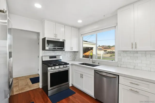 a kitchen with a sink stove top oven and microwave