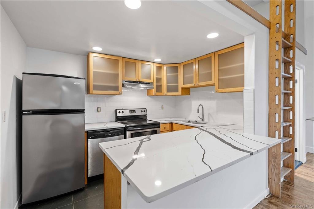 a kitchen with stainless steel appliances granite countertop a sink a refrigerator and a stove