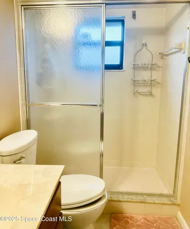 a bathroom with a toilet and a shower