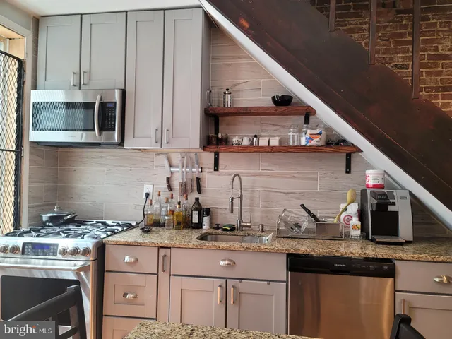 a kitchen with stainless steel appliances granite countertop a sink stove and cabinets