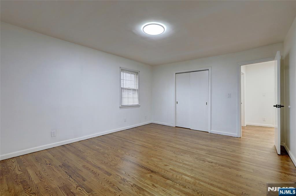 4-21 Saddle River Road, Unit 1 Fair Lawn, NJ 07410 - Photo 11 of 19 a view of an empty room with wooden floor and a window