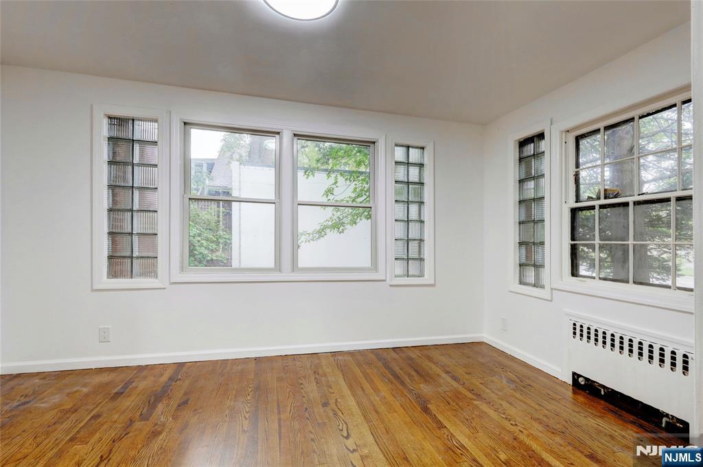 4-21 Saddle River Road, Unit 1 Fair Lawn, NJ 07410 - Photo 15 of 19 an empty room with wooden floor and windows