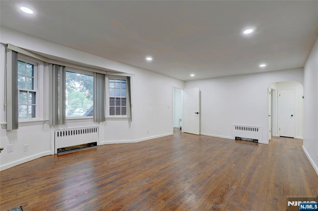 4-21 Saddle River Road, Unit 1 Fair Lawn, NJ 07410 - Photo 2 of 19 an empty room with wooden floor and windows