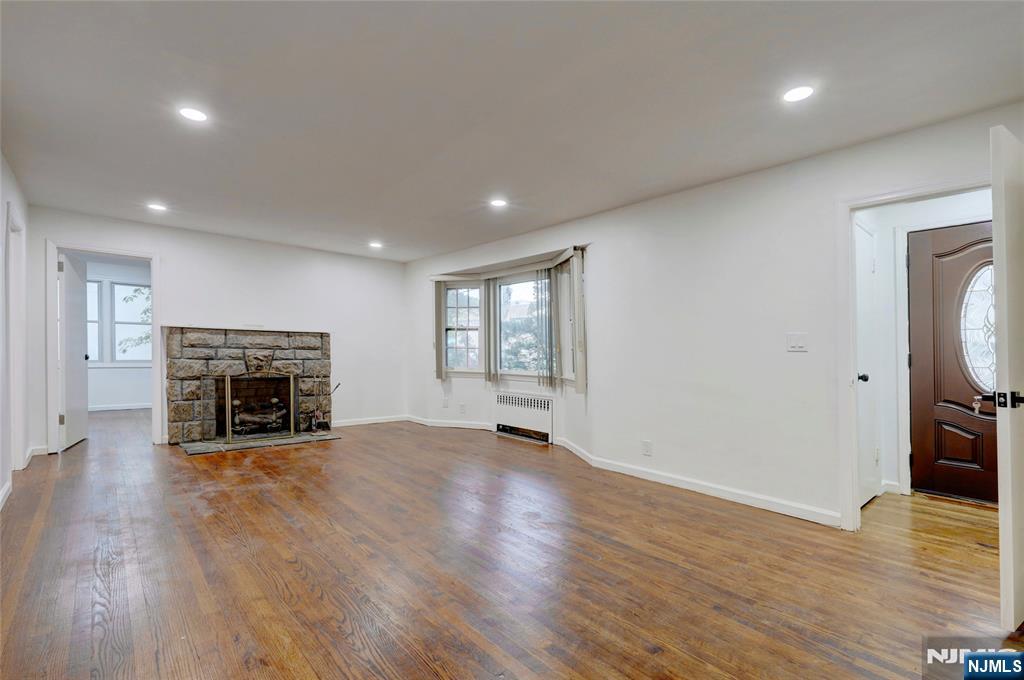 4-21 Saddle River Road, Unit 1 Fair Lawn, NJ 07410 - Photo 3 of 19 a view of an empty room with wooden floor fireplace and a window